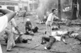 Vitimas vietnamita recebem os primeiros-socorros depois que uma bomba explodiu do lado de fora da Embaixada americana em Saigon, em 30 de março de 1965. Sob a fumaça, atrás dos destroços, estão dois americanos e vários vietnamitas mortos no atentado. (AP Photo/Horst Faas)